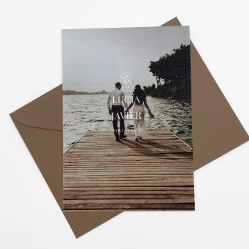 Invitación con foto de los novios acompañada de un sobre marrón